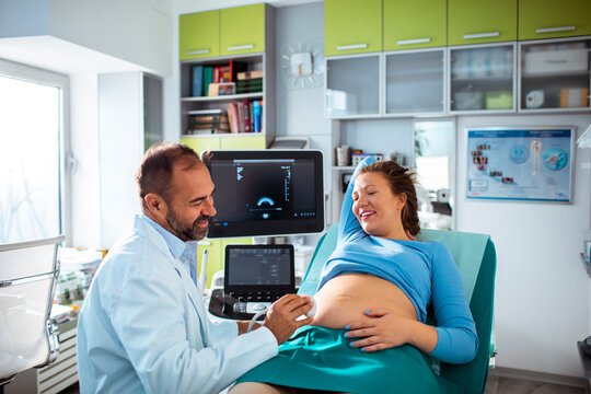 Doctor performing prenatal ultrasound on pregnant woman in clinic