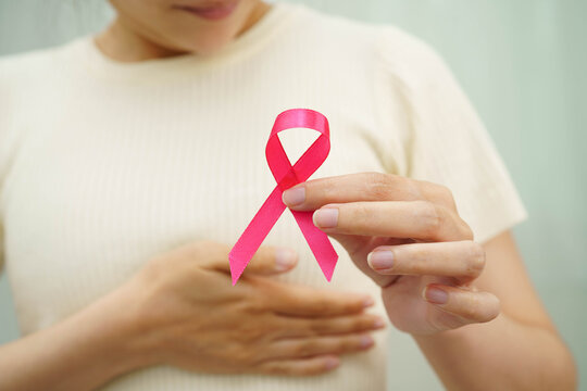 Asian woman with pink ribbon for October world breast cancer day.