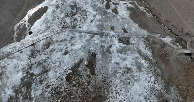 Drivier checking the road crossing the frozen river in Tibet, China	