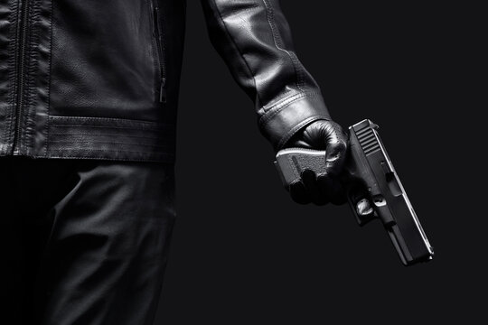 Man with gun on black background, closeup