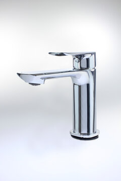 Modern chrome faucet stands sleekly against a soft white background. Its design emphasizes clean lines and minimalist elegance. isolated on clean white background with soft shadow, functional tools.
