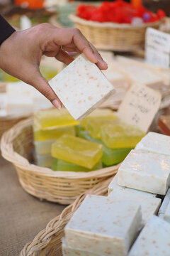 Hand selecting handmade soap at a market