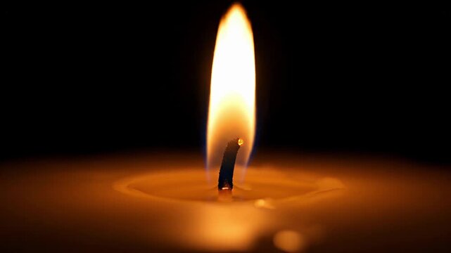 A single, warm candle flame burns brightly in the profound darkness, casting a soft, comforting glow that evokes peace and quiet contemplation, symbolizing hope and solace
