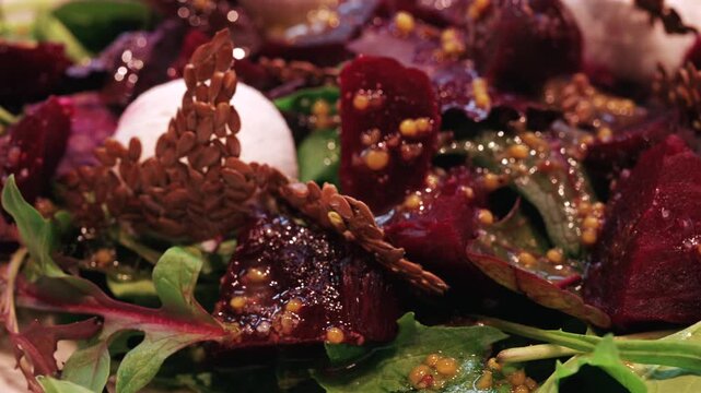 Close up of a beetroot salad with creamy cheese, seeds, and greens