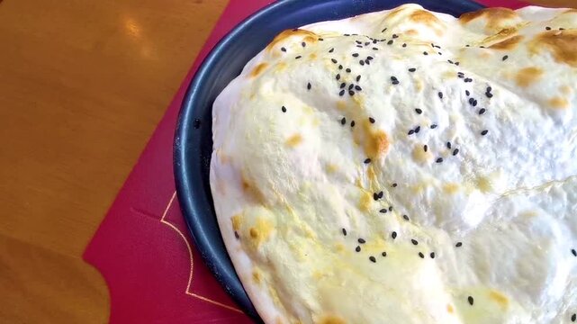 Golden baked Turkish flatbread topped with black sesame restaurant dish in Patong Beach Kathu District Phuket Island Province Southern Thailand in Southeast Asia.