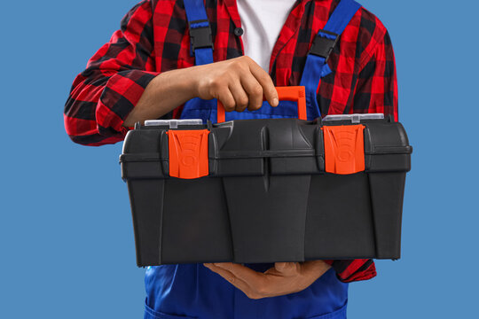 Male constructor with tool kit on blue background, closeup
