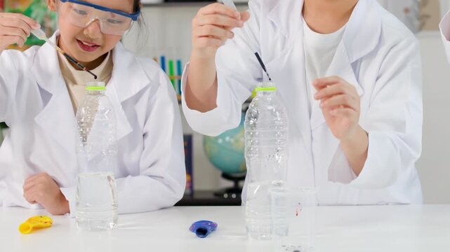 Two Asian Students Conducting Chemistry Experiment with Liquid in Plastic Bottles