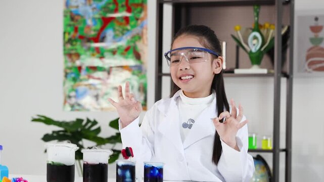 Young Asian Girl in Lab Coat Celebrating Successful Science Experiment