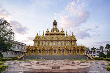 The golden castle temple stands centered above the wide forecourt. Soft evening clouds spread across the open sky. © Surachetsh