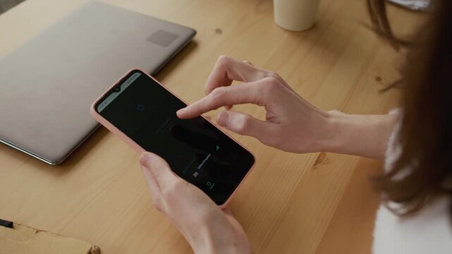 Over-shoulder shot of anonymous woman running mobile app on smartphone, choosing server from list, then establishing secure VPN connection for browsing websites and online privacy