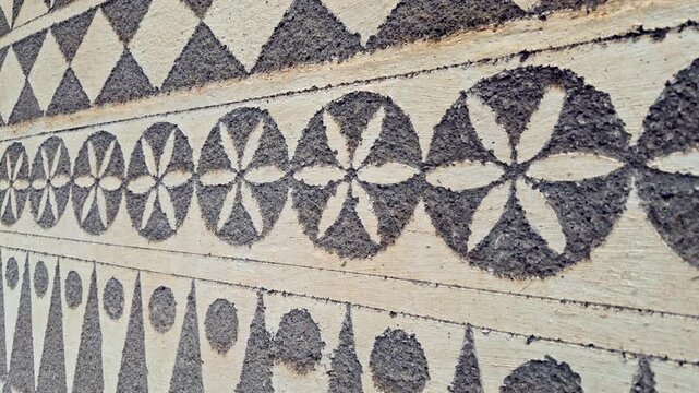 Close up of traditional geometric sgraffito patterns on an exterior wall. Detailed stone texture with flower and diamond motifs, perfect for architecture and cultural heritage.