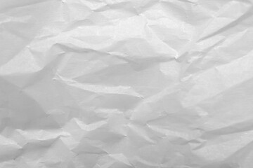 Fototapeta premium White crumpled paper texture background with soft creases, wrinkled sheet surface, abstract monochrome backdrop for design, packaging, stationery, mockup, and minimal template
