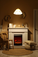 Obraz premium Interior of dark living room with fireplace, chair and glowing lamp at night