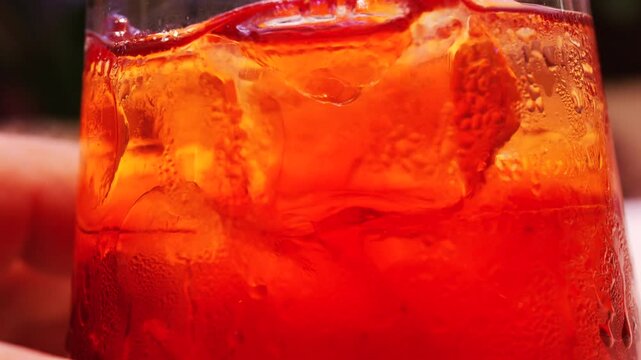 Detailed macro of a refreshing cocktail with ice cubes and water droplets on glass surface