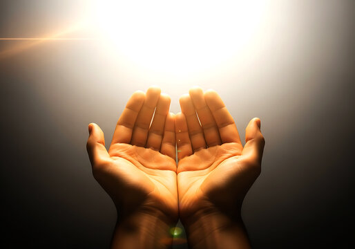 Open hands raised in prayer with glowing light between palms