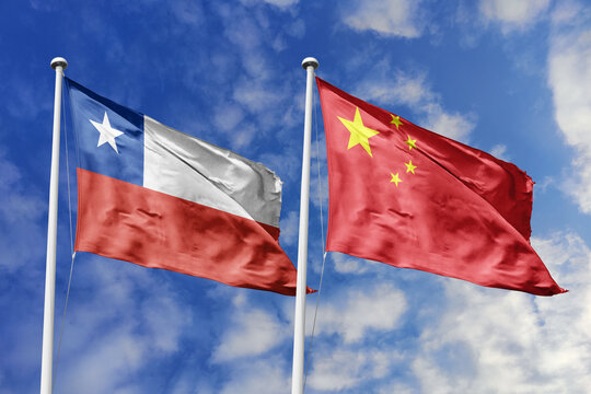 Chile and China flags waving in a clear blue sky, symbolizing a powerful diplomacy, expanding global trade, a strategic partnership, and a shared vision of unity for a sustainable future.