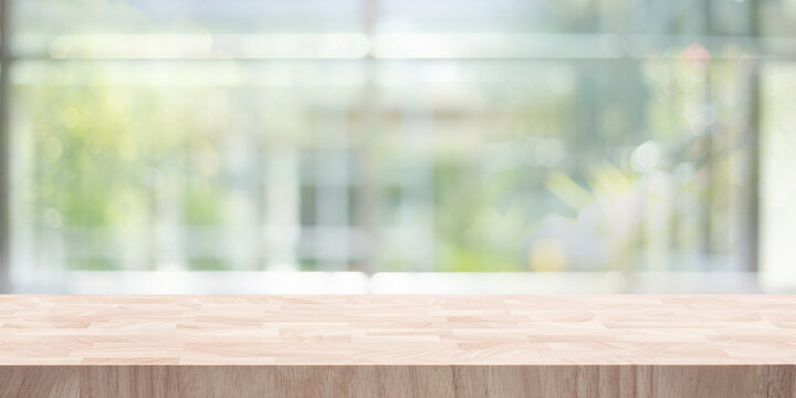 Front Focus.Table top,counter top with beautiful blur big glass wall texture with fresh garden.For material product design
