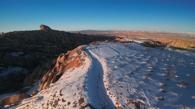 Snow-covered Sandstone Mountains in Pigeon valley Near U&ccedil;hisar In Cappadocia Region In Turkey. FPV aerial drone