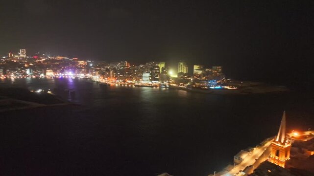 Stunning Night View Of Valletta, Sliema, Malta, With Illuminated Basilica of Our Lady of Mount Carmel Revealed. aerial panning shot
