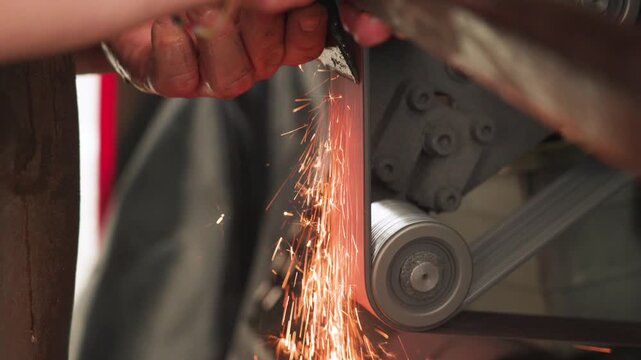 Slow Motion shot of a hatchet is being sharpened on a grinding machine in Malaysia, with sparks flying, highlighting tool maintenance, precision work, and industrial craftsmanship.