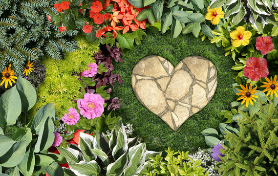 Gardening love and loving the hobby of maintaining the garden with an ornamental landscaped flowerbed and spring gardening concept shaped as a heart with a mowed lawn and grass representing the joy of