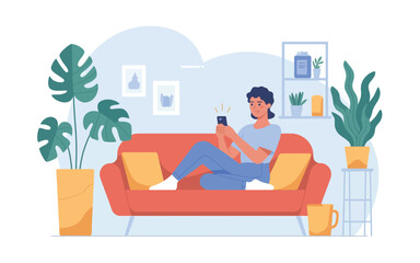 Fototapeta premium A young woman relaxes on a red sofa using her smartphone indoors