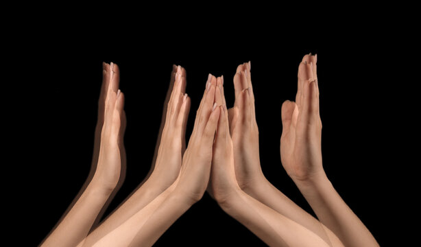Stroboscopic photo of female hands moving on dark background