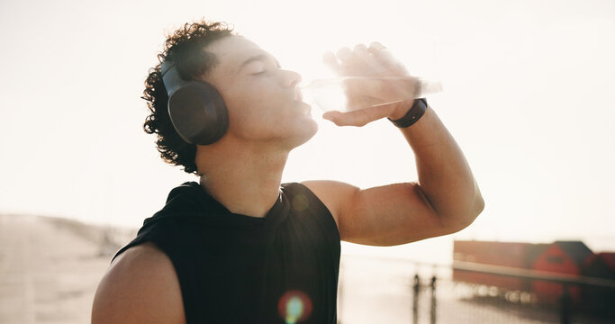 Fitness, drinking water and man in city, wellness and aqua for hydration, exercise and sunshine. Outdoor, athlete and person with h2o liquid, electrolytes and workout for health benefits or nutrition