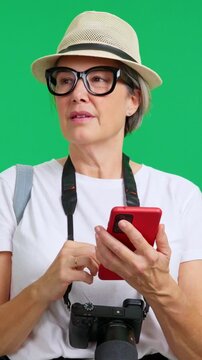 Mature lost female tourist using phone and asking for directions
