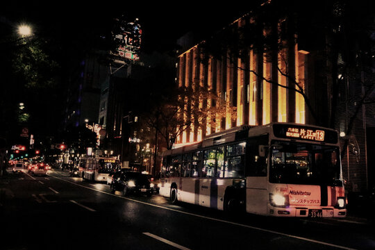 Nishitetsu Bus on a busy urban street at night with illuminated city buildings and traffic in the Tenjin entertainment district of Fukuoka - Fukuoka, Japan, August 27, 2018