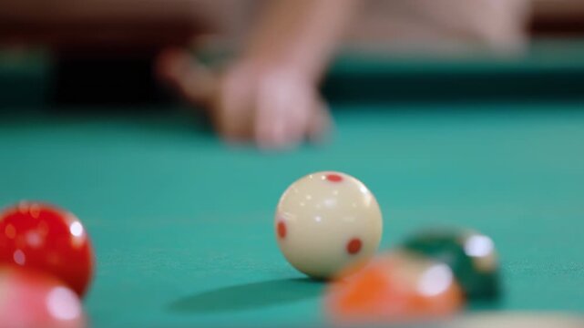 Billiard pool table shows snooker balls arranged for game play, is hitting by the white cue ball with the cue, vintage green pool game object, showing signs of age and use. Classic cue sport equipment