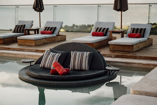 This image features a stylish poolside lounge area with chic seating, presenting an inviting atmosphere for relaxation and enjoyment in a luxurious environment.
