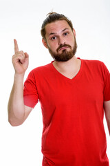 Fototapeta premium Bearded Young Man in Red V-Neck T-Shirt Pointing Up - Casual Male Idea Concept