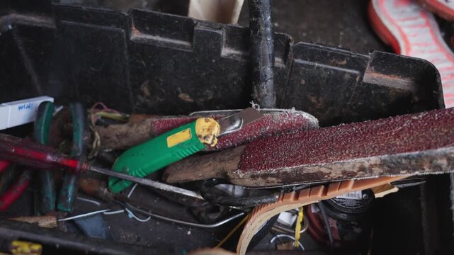 Close up of a cobbler&rsquo;s toolbox with rasp and sanding tools in Malaysia. Authentic workspace scene highlighting manual labor, repair craft, and traditional skills.