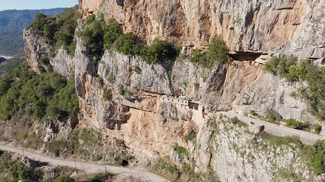 Slow panning drone shot of Holy Kipinas Monastery built into a steep rock face in Tzoumerka, Epirus, Greece