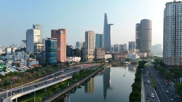 Vehicles travel on the streets of Ho Chi Minh City in the early morning ,alongside a picturesque river| Ho Chi Minh Skyline - Vietnam