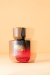 Bold red perfume bottle with motion blur, at beige background. A visually striking concept in fragrance, glamour, and high-end beauty branding. © vasanty