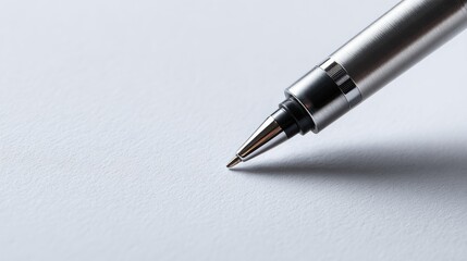 Fototapeta premium A metallic pen poised over blank paper, ready for writing. This photo captures the elegance of a simple writing instrument