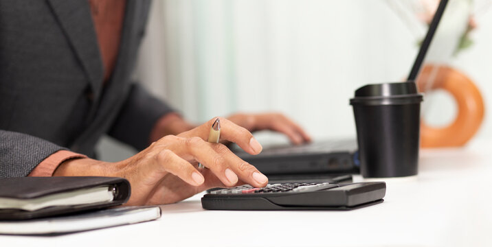 businessman use calculator with calculate budget or tax at workplace