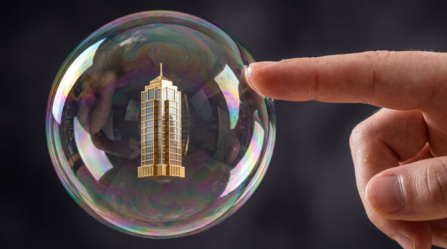 A finger reaching to touch a golden skyscraper inside a fragile iridescent soap bubble