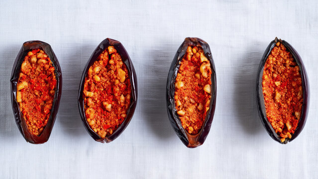 Overhead view of authentic Lebanese Makdous: Preserved Baby Eggplants in Oil stuffed with walnuts, garlic and red bell pepper. Concept of traditional Levantine specialties. 