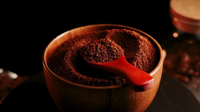 Ground coffee is displayed in a wooden bowl