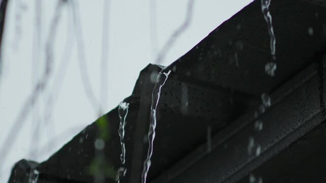 Rainwater Flowing from Rooftop Edge During Rainy Day, Close-Up