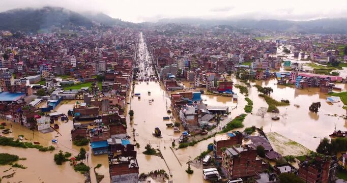 Drone shot of heavy monsoon flooding in Banepa NEpal with river overflow submerging settlements, trucks, and vehicles, exposing unmanaged urban planning and climate vulnerability near Kathmandu