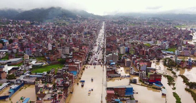Aerial view of severe monsoon flooding in Banepa where river overflow submerges settlements, trucks and vehicles, causing Araniko Highway blockade and exposing urban planning issues near Kathmandu