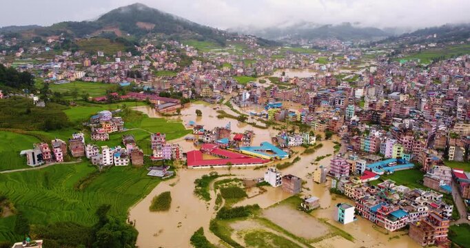 Drone shot of intense monsoon floodwaters in Banepa Nepal overwhelming riverbanks and submerging settlements, highlighting drainage failures and climate vulnerability near Kathmandu