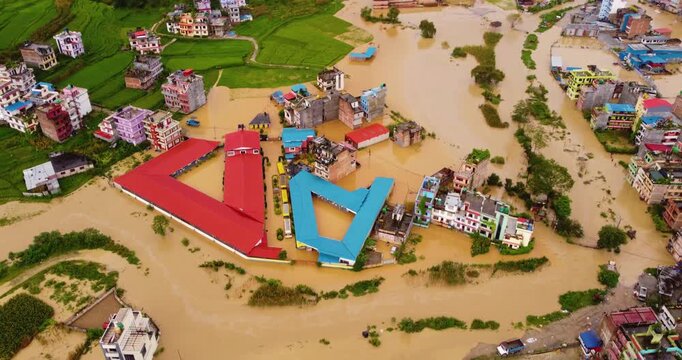 Aerial shot of Banepa inundated by heavy rainfall with river overflow submerging buildings and green fields, highlighting unmanaged urban development in Nepal.