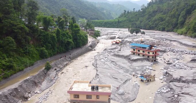 Drone shot of abandoned houses stranded within the Melamchi River after monsoon flooding, showing severe damage and isolation in Nepal.