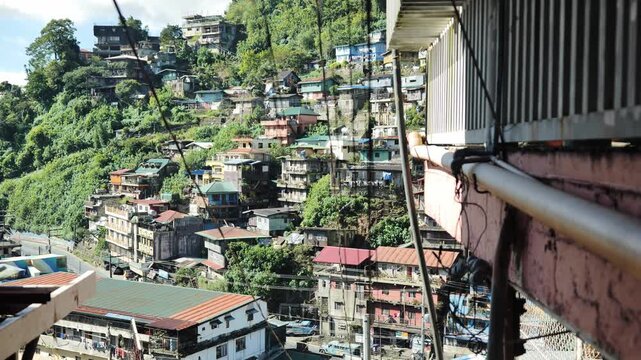 Handheld tilt reveals stacked colorful homes on hillside Stobosa Benguet