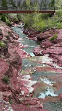 Stream flowing through layered red rock formations in Waterton Lakes National Park